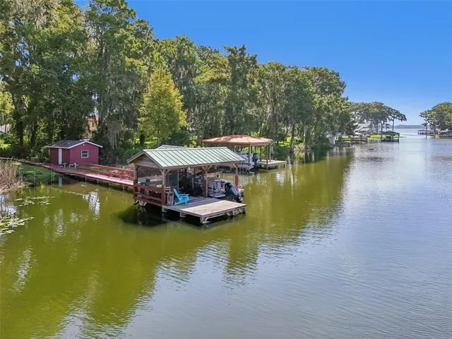 an aerial view of residential houses with outdoor space and lake view