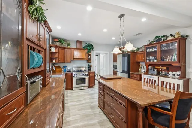 a kitchen with granite countertop a table chairs stove and cabinets