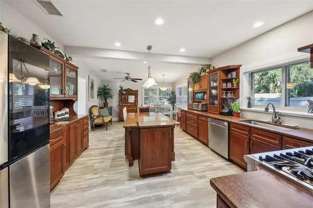 a large kitchen with stainless steel appliances granite countertop a large stove a sink dishwasher and white cabinets with wooden floor