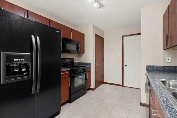a kitchen with stainless steel appliances granite countertop a refrigerator and a stove