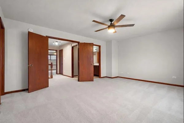 an empty room with closet and a ceiling fan