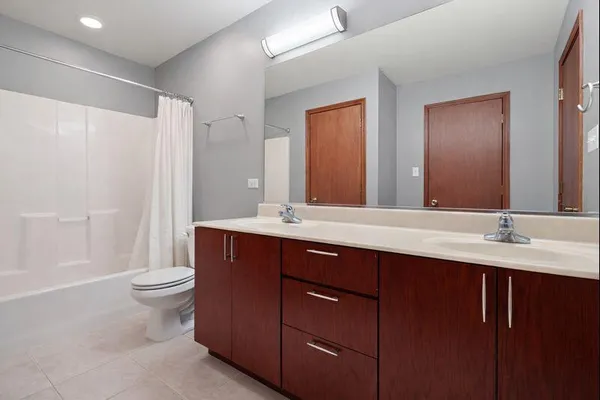 a bathroom with a double vanity sink toilet and a mirror