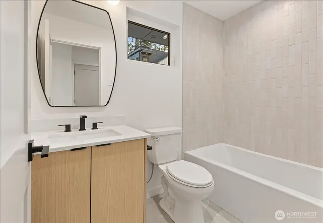 a bathroom with a granite countertop toilet sink and mirror