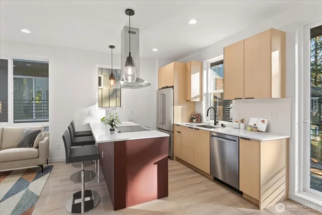 a kitchen with stainless steel appliances kitchen island granite countertop a sink and a refrigerator