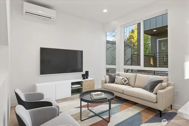 a living room with furniture a flat screen tv and a large window