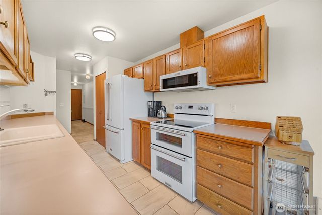 a kitchen with stainless steel appliances a stove a sink and a refrigerator