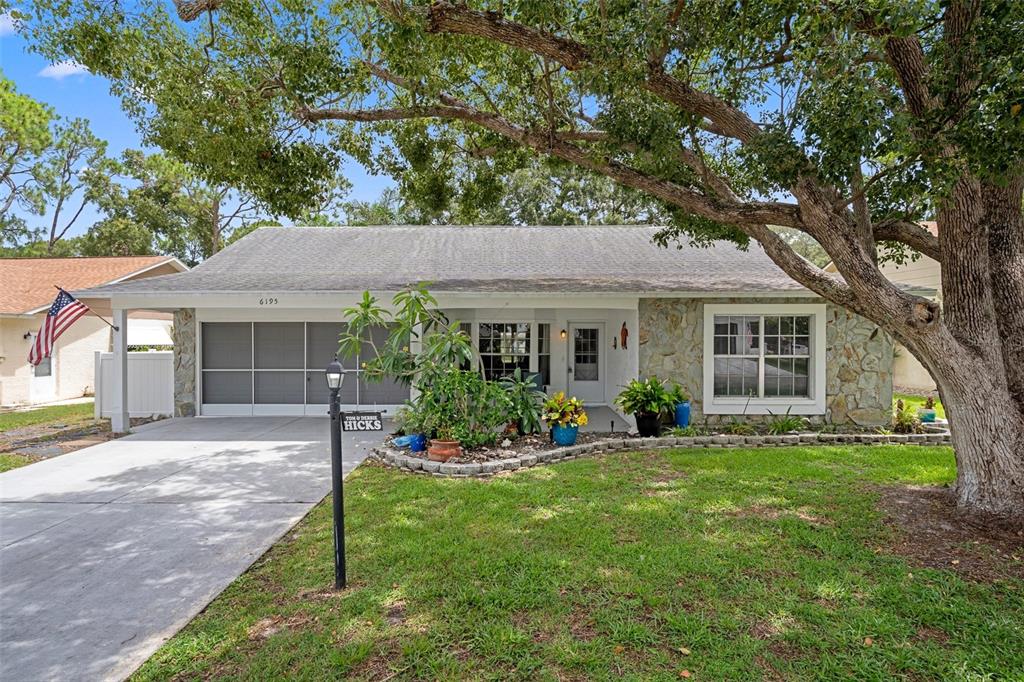 6195 Ocean Pines Lane Spring Hill, FL 34606 - Photo 1 of 1 a front view of a house with a garden and porch