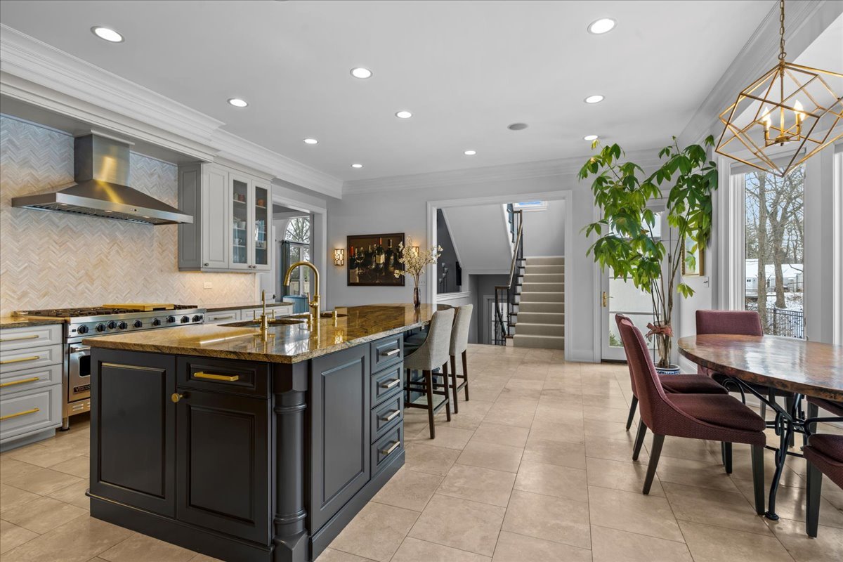 697 Bluff Road Lake Bluff, IL 60044 - Photo 15 of 49 a kitchen with stainless steel appliances granite countertop a stove top oven a dining table and chairs with wooden floor