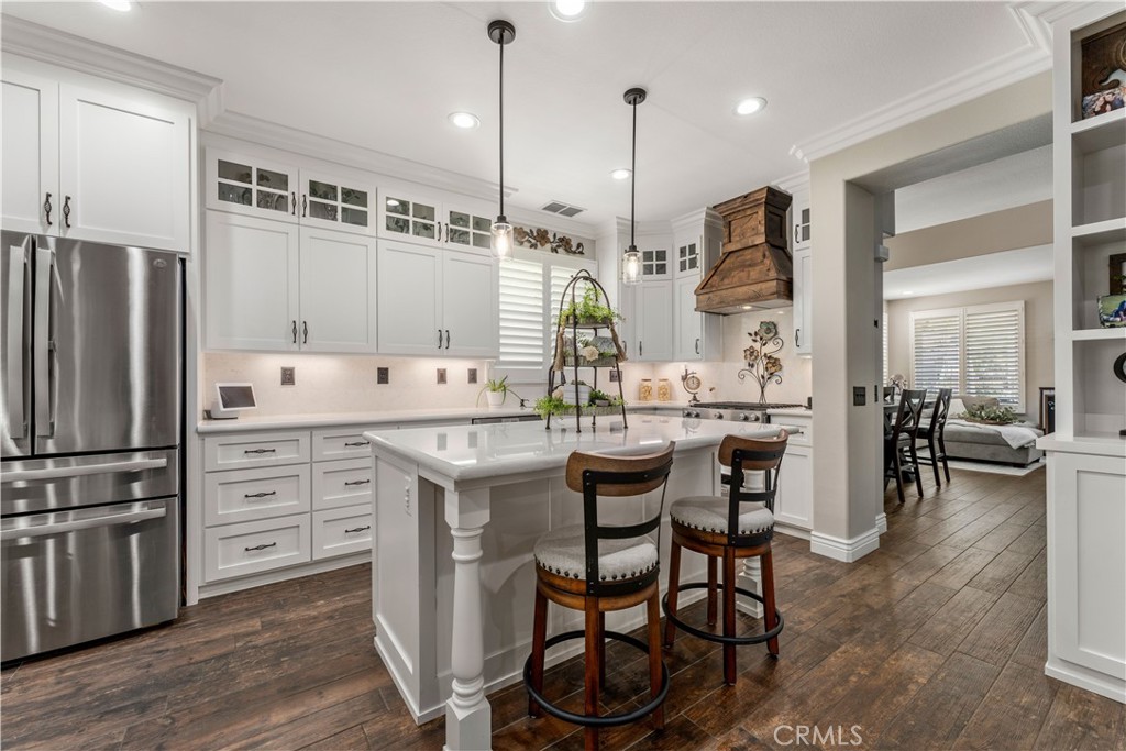 8750 East Heatherwood Road Anaheim Hills, CA 92808 - Photo 2 of 60 a kitchen with stainless steel appliances kitchen island granite countertop a table chairs stove and white cabinets
