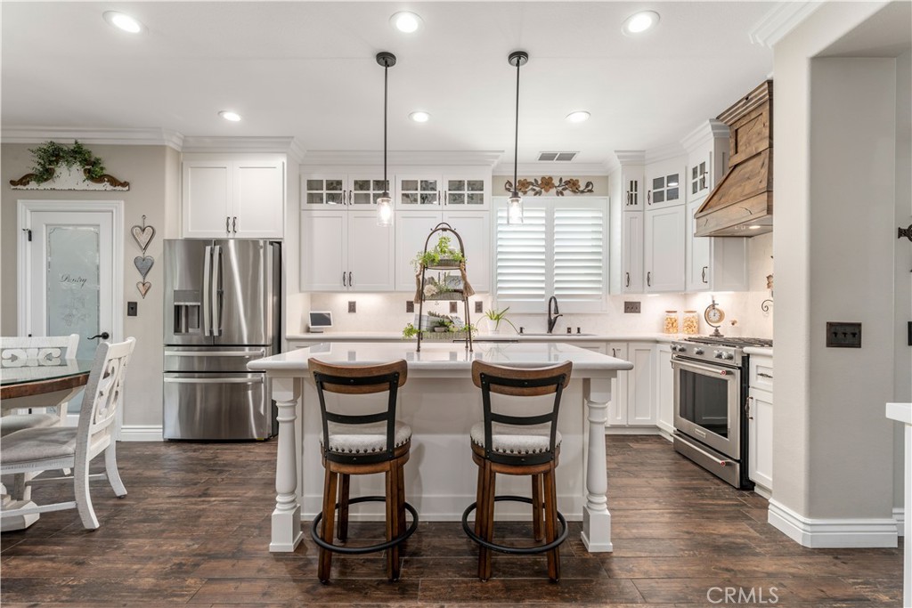 8750 East Heatherwood Road Anaheim Hills, CA 92808 - Photo 8 of 60 a kitchen with stainless steel appliances kitchen island granite countertop a table chairs stove and refrigerator