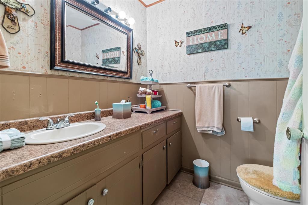 703 Amy Street Canton, TX 75103 - Photo 18 of 32 a bathroom with a granite countertop toilet sink and mirror