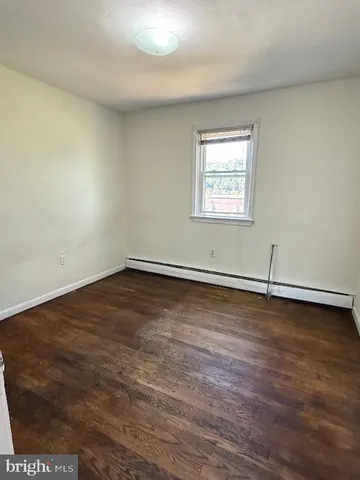 a view of a room with wooden floor and window