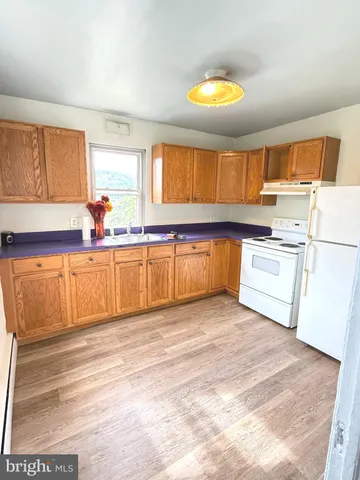 a kitchen with stainless steel appliances granite countertop a sink cabinets and wooden floor