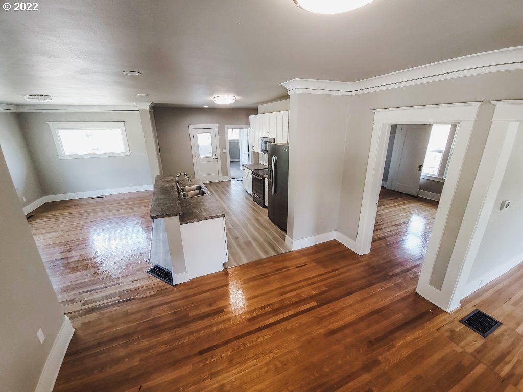 324 Northwest 9th Street Pendleton, OR 97801 - Photo 15 of 24 a living room with kitchen island granite countertop wooden floor and a view of kitchen