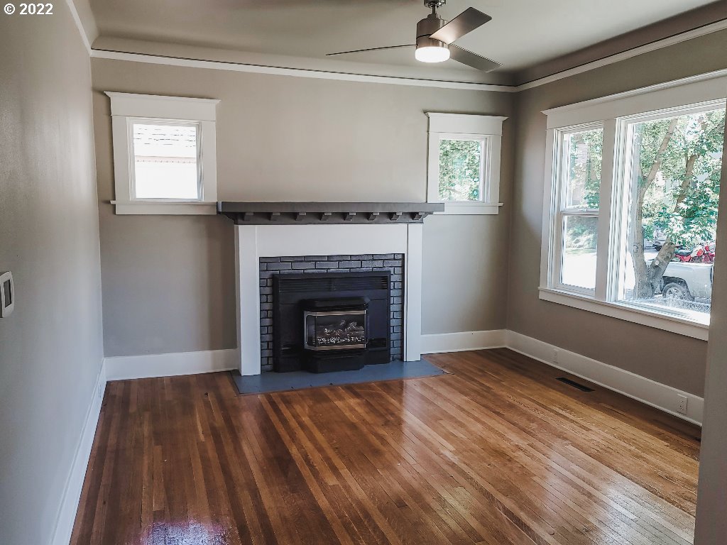 324 Northwest 9th Street Pendleton, OR 97801 - Photo 9 of 24 a view of an empty room with wooden floor fireplace and a window