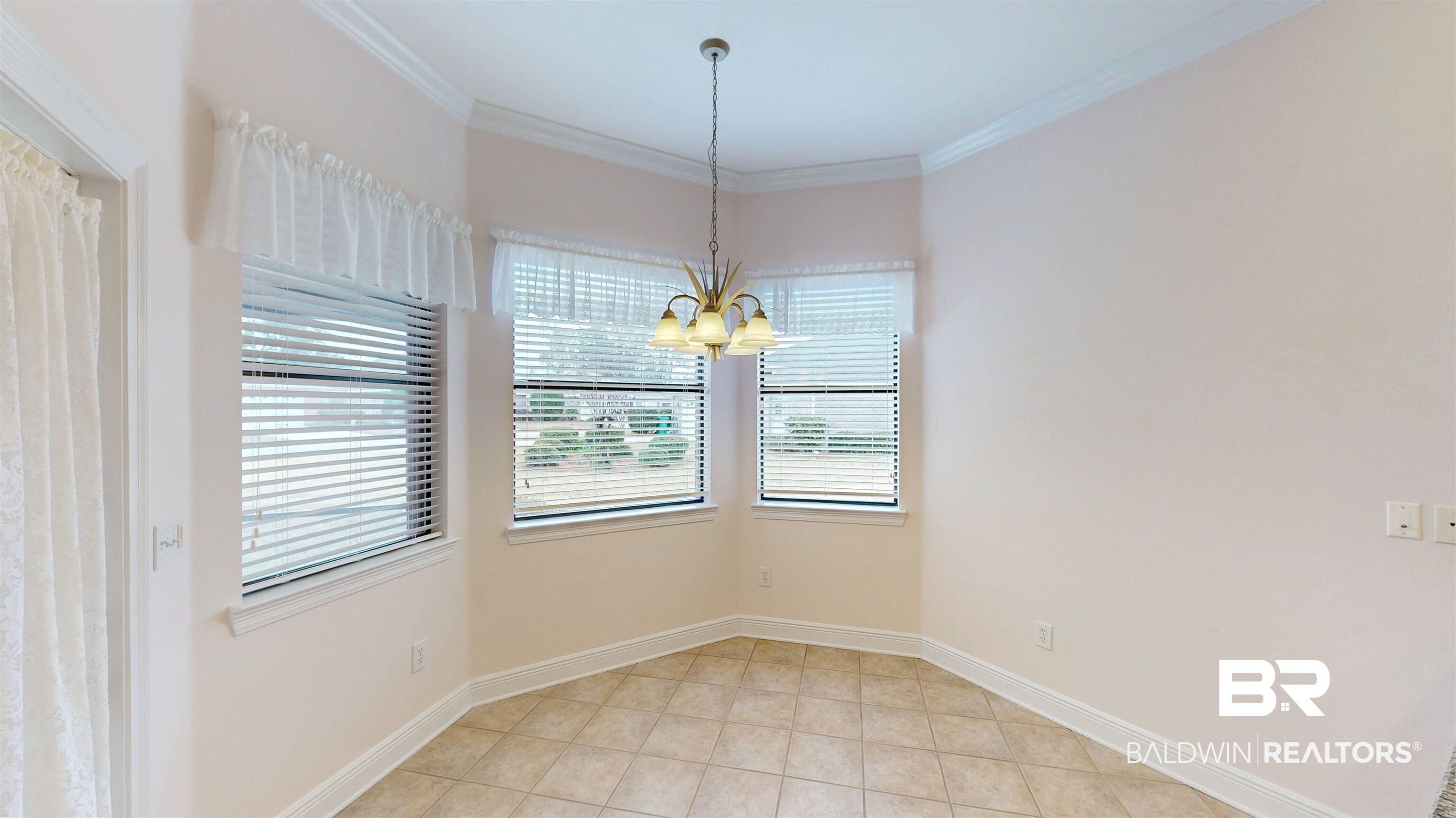 214 Hemingway Loop Foley, AL 36535 - Photo 16 of 67 Unfurnished dining area featuring crown molding, a chandelier, and light tile patterned floors