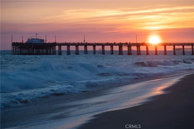 a kitchen with stainless steel appliances a dining table chairs sink and cabinets