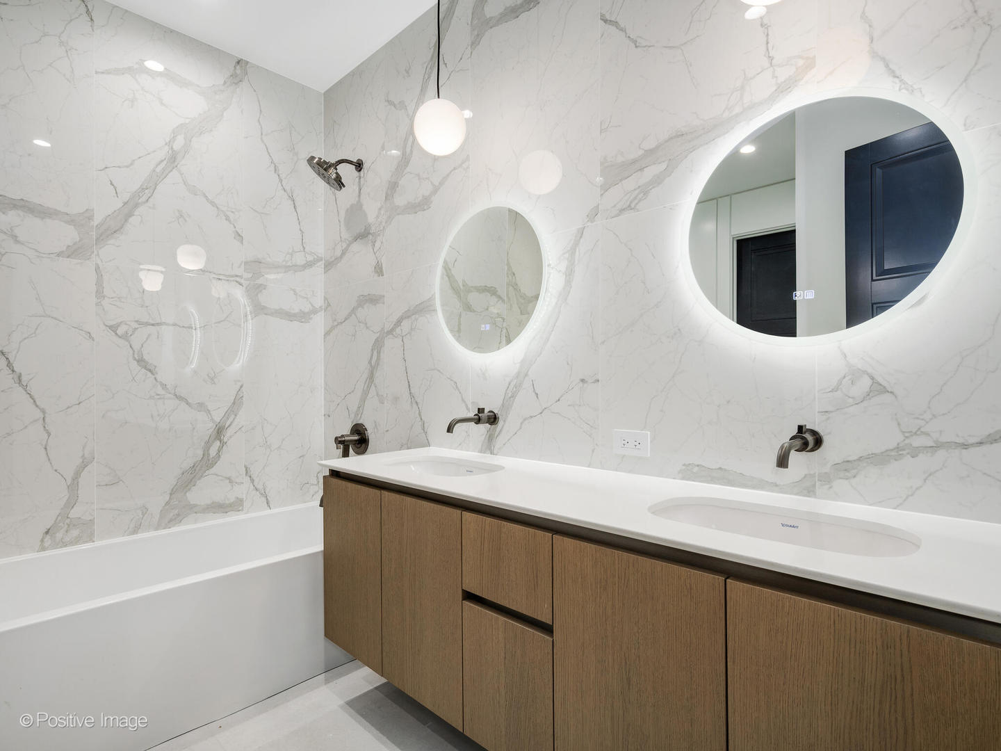 1216 West George Street Chicago, IL 60657 - Photo 22 of 42 a bathroom with a double vanity sink and mirror