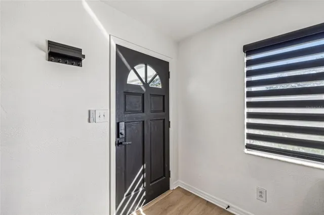 a view of a hallway with wooden floor and a window
