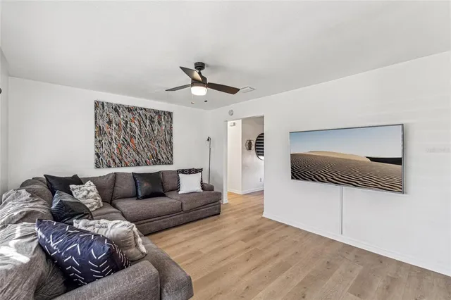 a living room with furniture and a ceiling fan
