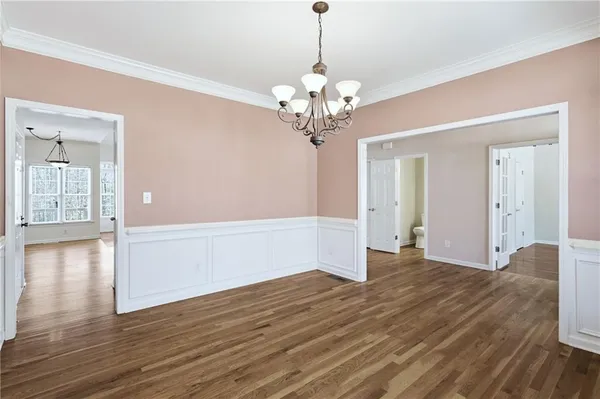 a view of a livingroom with a chandelier fan and wooden floor