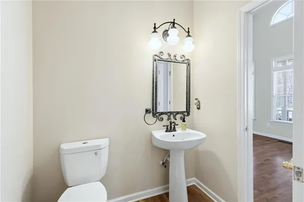 a bathroom with a sink toilet and a mirror