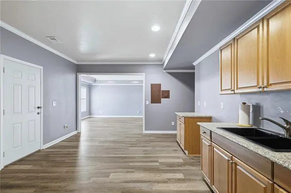 a kitchen with a sink cabinets and wooden floor