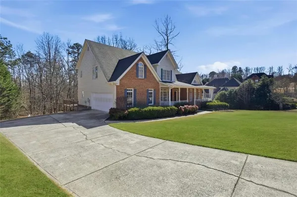 a front view of a house with a yard and trees