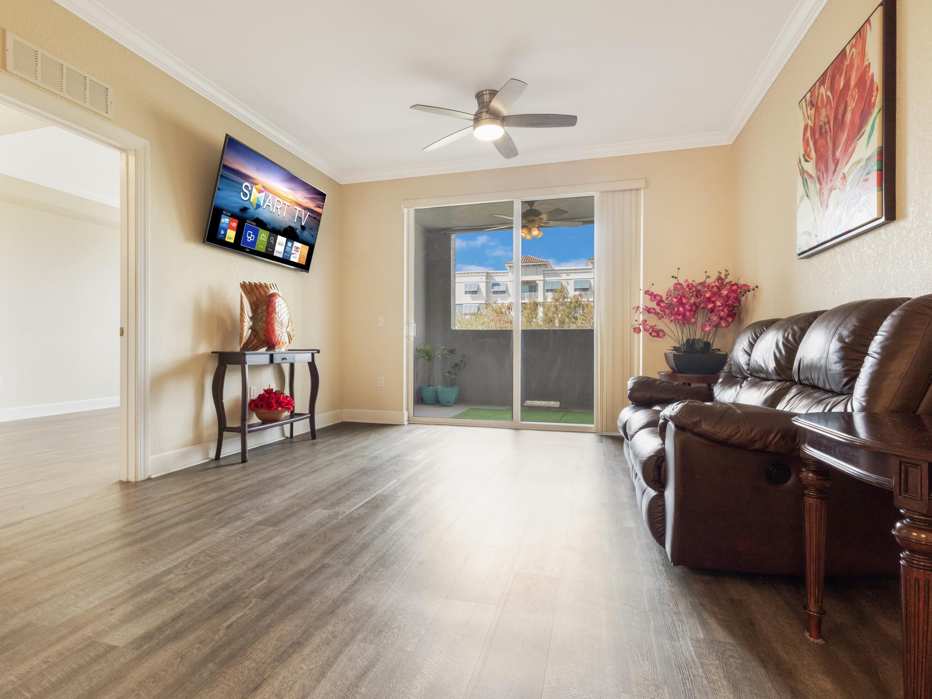 1690 Renaissance Commons Boulevard, Unit 1412 Boynton Beach, FL 33426 - Photo 9 of 49 a living room with furniture and wooden floor