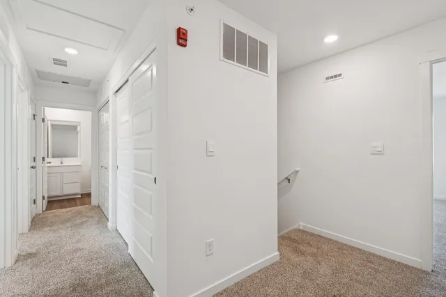 a view of a hallway with a livingroom and a bathroom