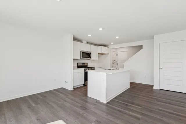 a kitchen with wooden floors and white walls
