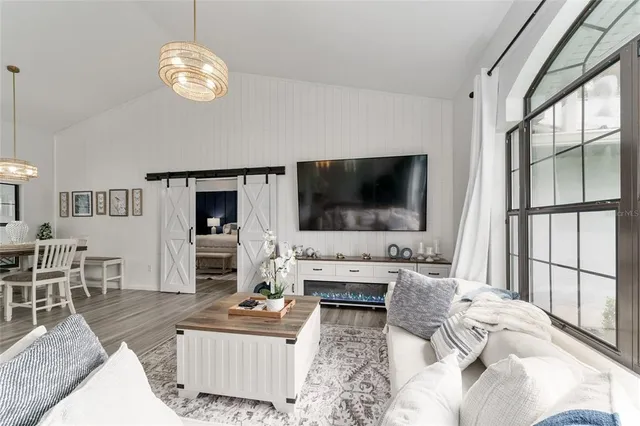 a kitchen with stainless steel appliances kitchen island granite countertop a stove a sink a dining table and chairs with wooden floor