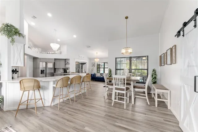 a room with stainless steel appliances kitchen island a table and chairs in it