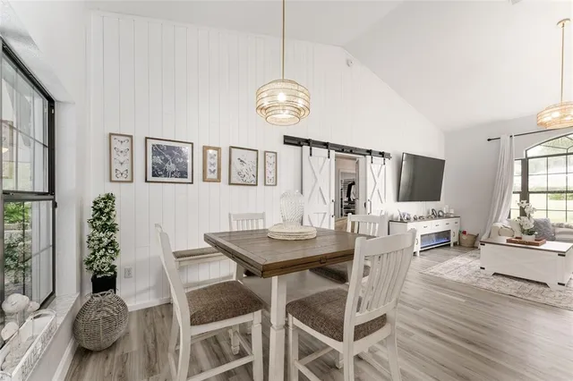a living room with furniture a flat screen tv and a large window