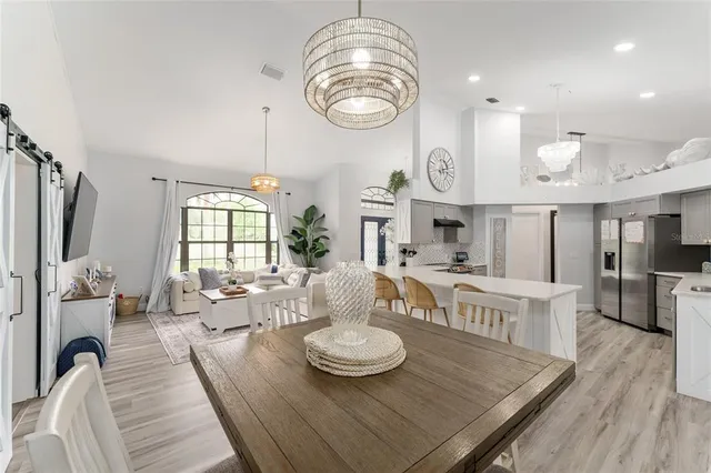 a view of a room with kitchen island stainless steel appliances wooden floor and window