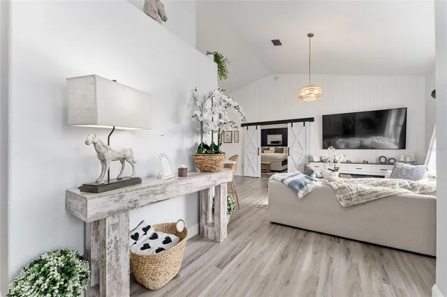 a living room with furniture chandelier and a potted plant