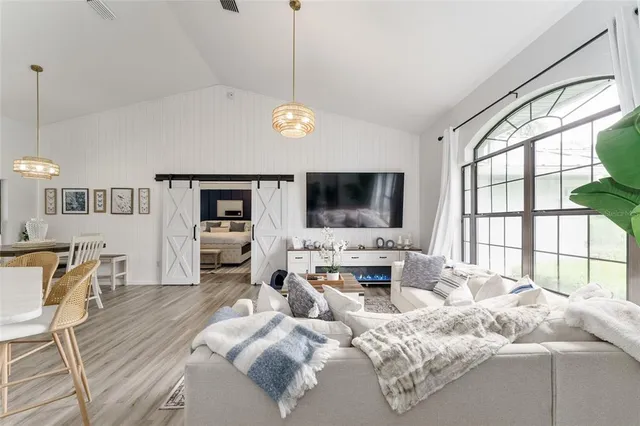 a living room with furniture flat screen tv and a large window