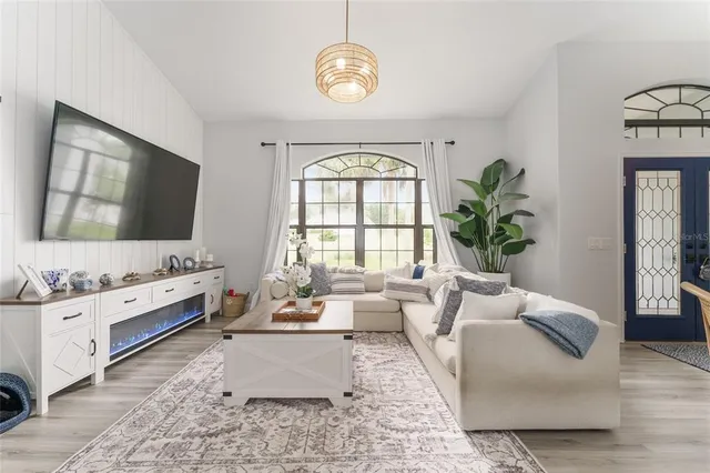 a dining room with furniture a chandelier and wooden floor