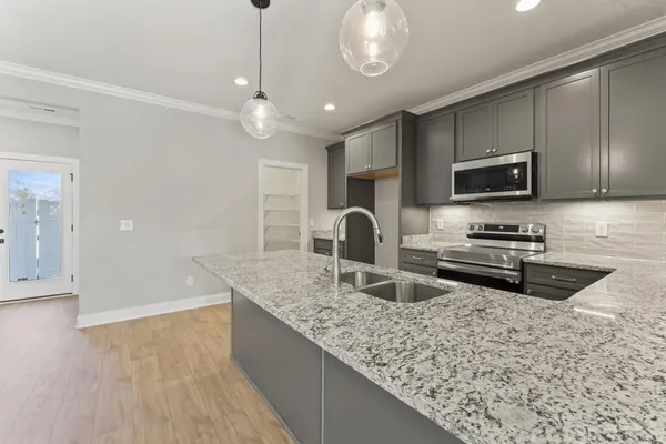 a kitchen with stainless steel appliances granite countertop a sink refrigerator and microwave
