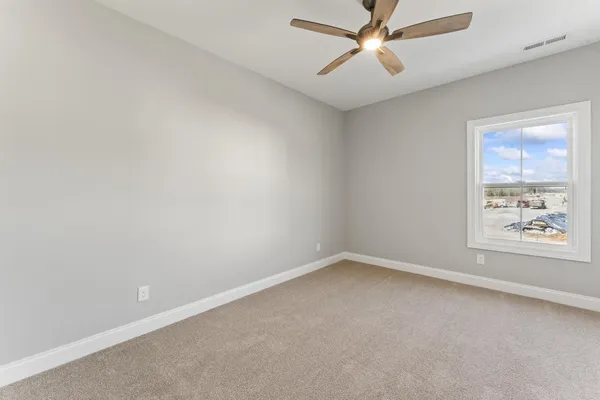 an empty room with a window and a fan
