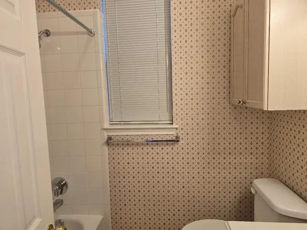a bathroom with a toilet and a shower curtain