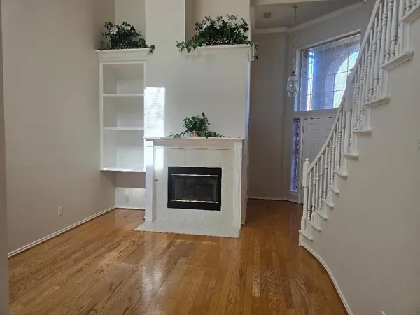 a view of a livingroom with wooden floor and a fireplace