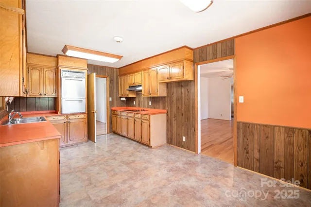 a open kitchen with stainless steel appliances a refrigerator and a stove top oven
