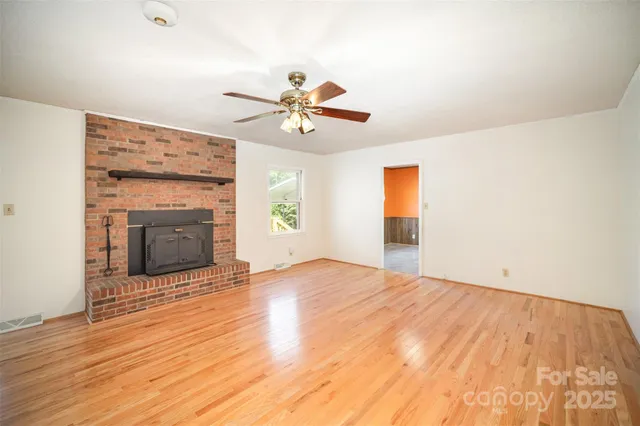 a view of an empty room with window and fireplace