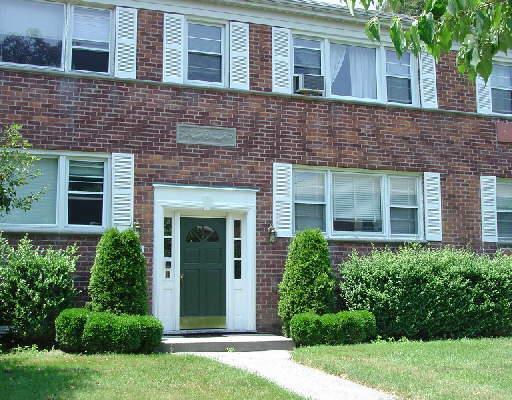 242 Glenbrook Road, Unit 34C Stamford, CT 06906 - Photo 1 of 1 front view of a brick house with a yard
