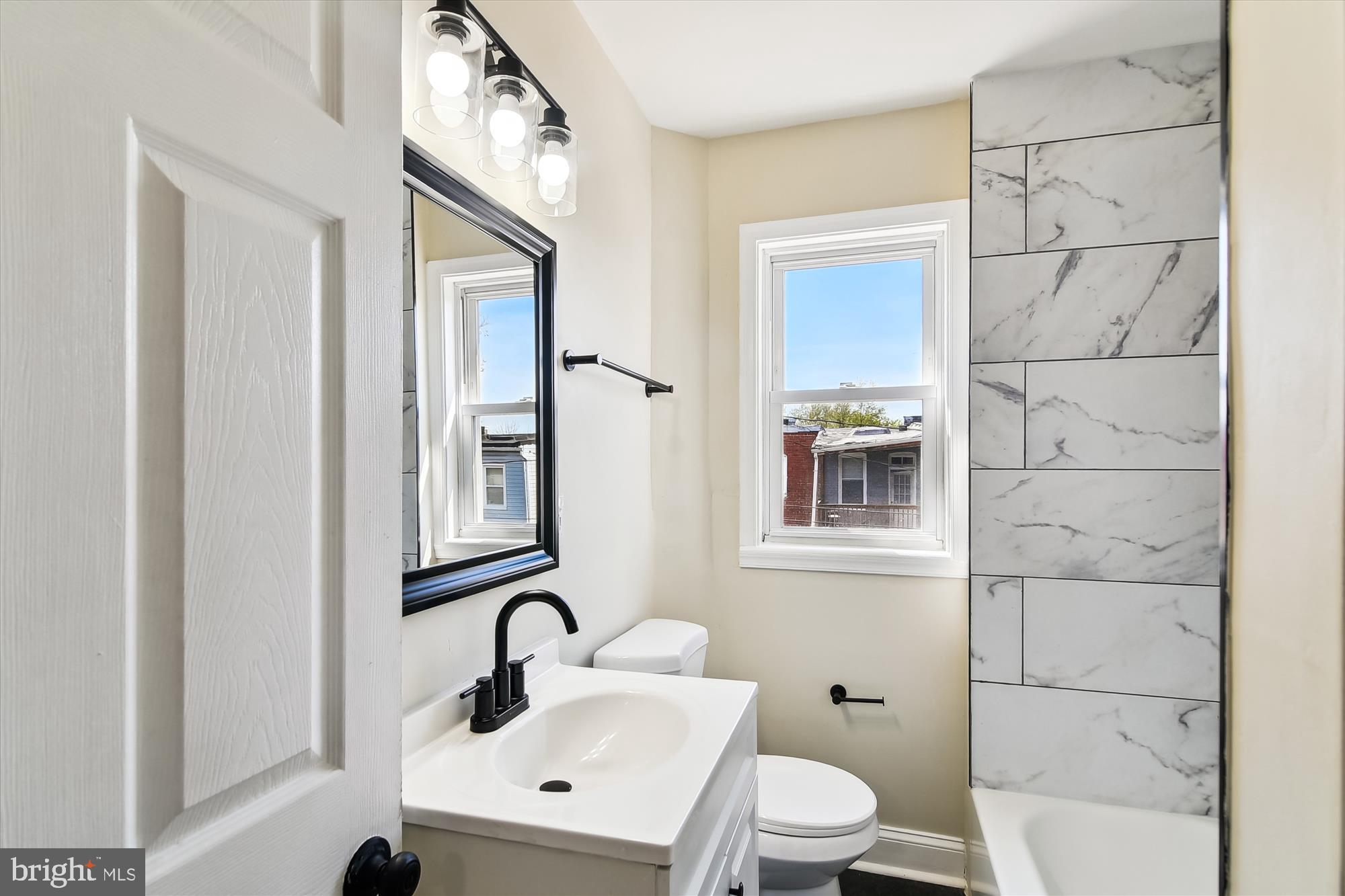3312 Royce Avenue Baltimore, MD 21215 - Photo 12 of 20 a bathroom with a toilet sink and mirror