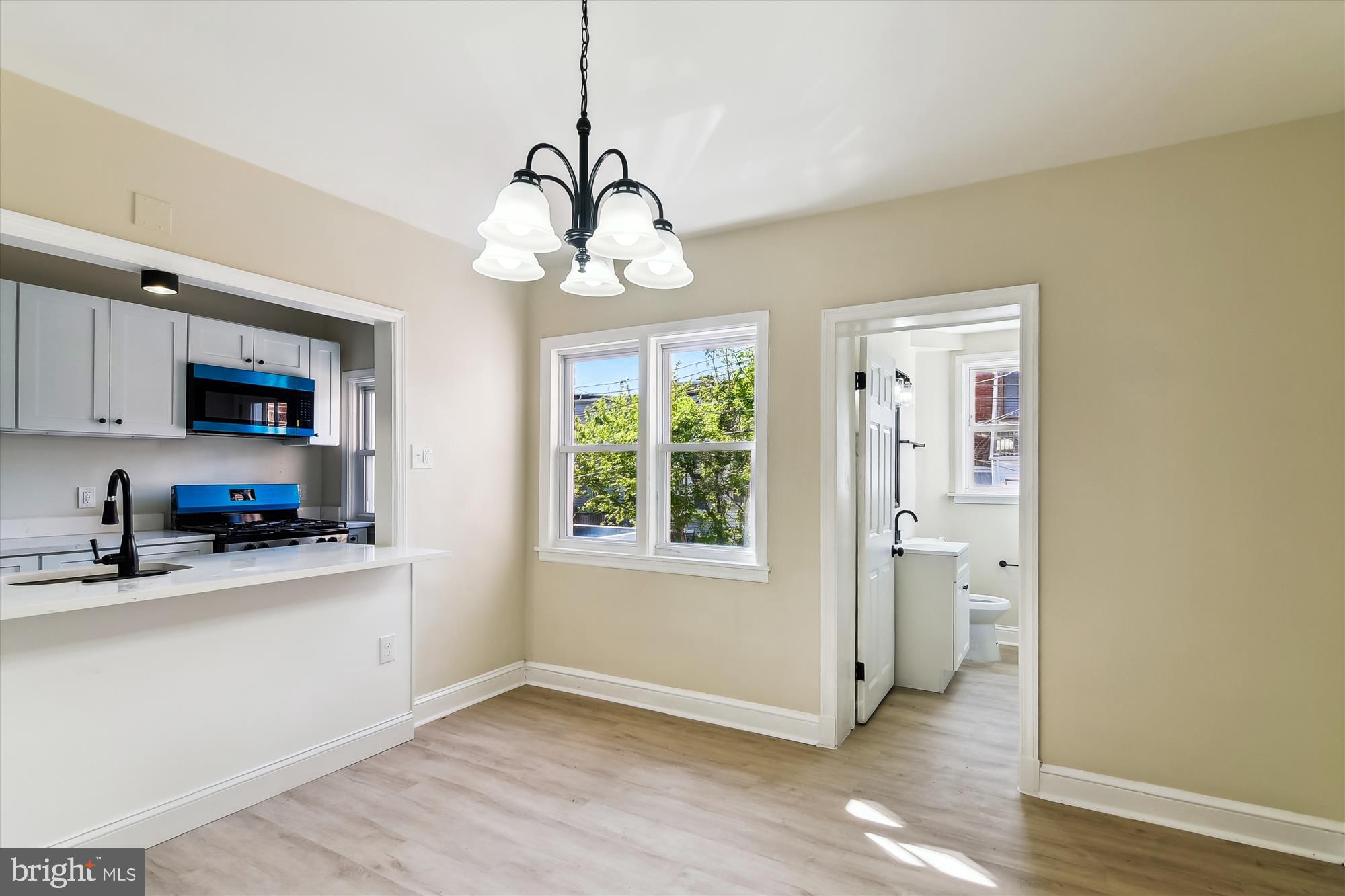 3312 Royce Avenue Baltimore, MD 21215 - Photo 5 of 20 a kitchen that has a lot of stainless steel appliances wooden floor and a window