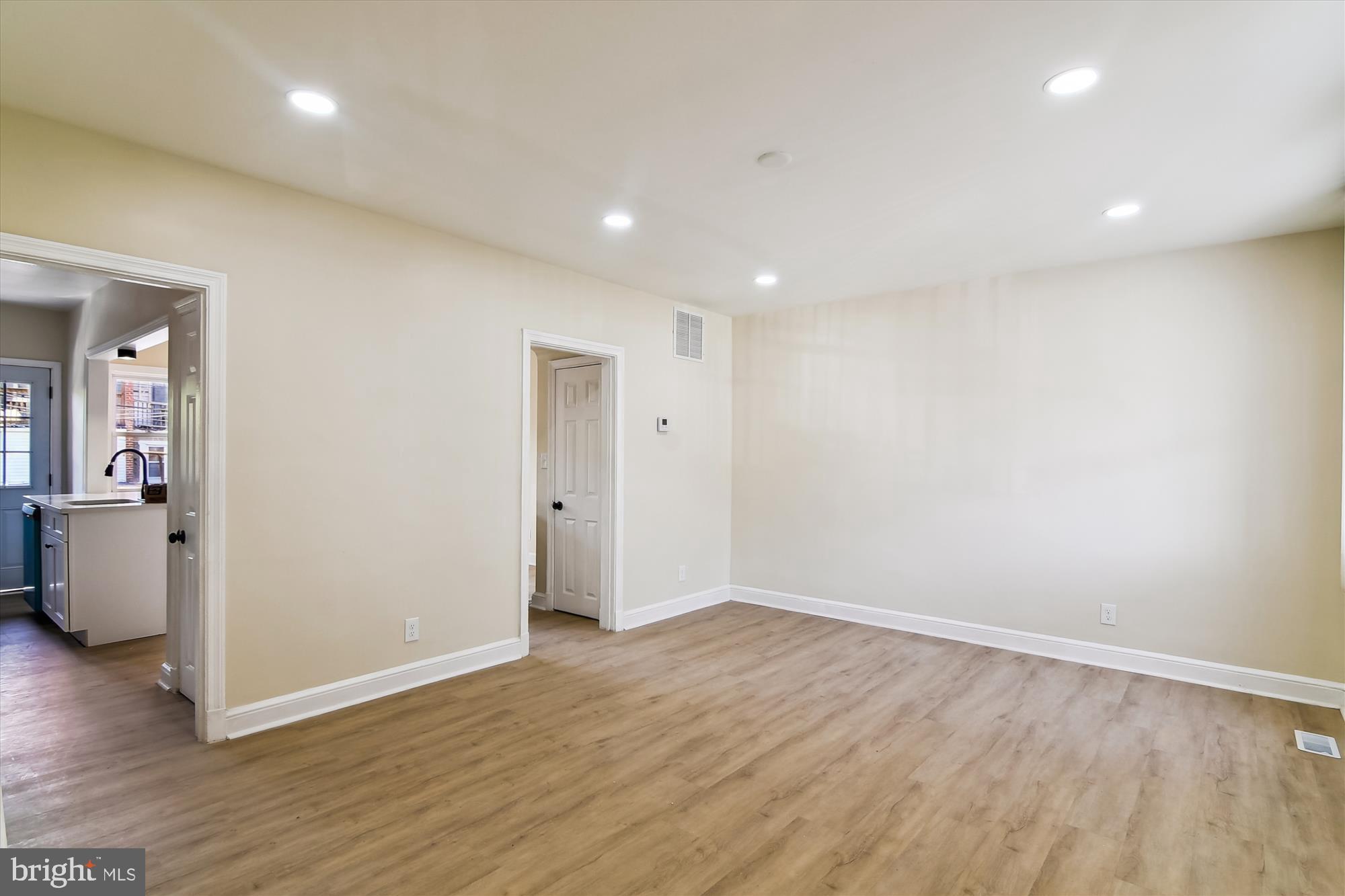 3312 Royce Avenue Baltimore, MD 21215 - Photo 9 of 20 an empty room with wooden floor and windows