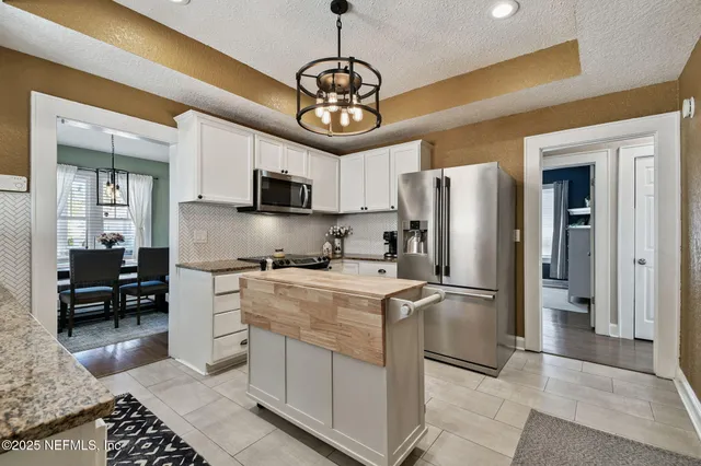 a view of a hallway with wooden floor and a livingroom