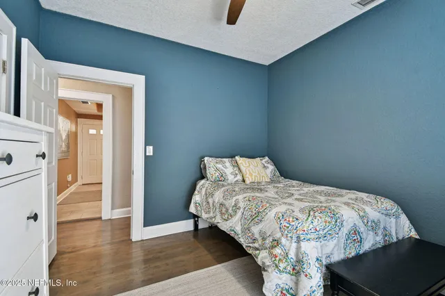 a bedroom with a bed and a flat tv screen on dresser